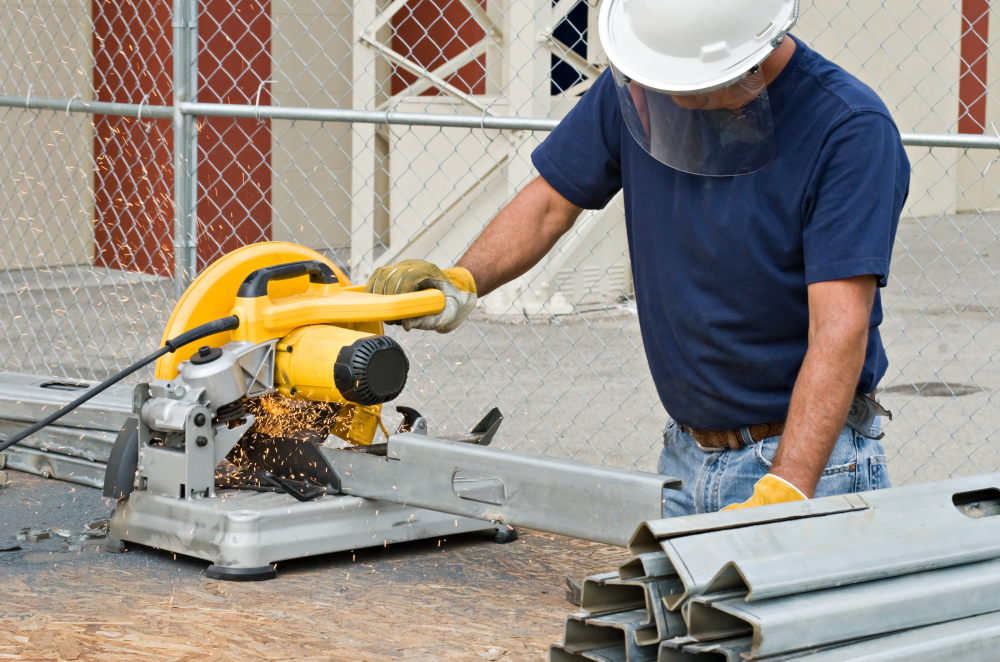 RAM Steel worker cutting steel framing with a saw